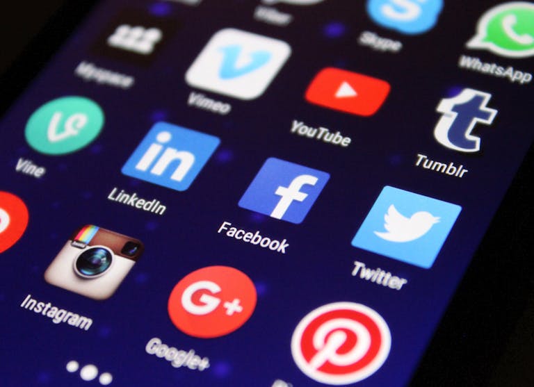 Zbliżenie ekranu smartfona pokazujące różne ikony aplikacji mediów społecznościowych, takie jak Facebook i Twitter pokazujące przykładowe Zbliżenie ekranu smartfona pokazujące ikony aplikacji mediów społecznościowych, takich jak Facebook i Twitter, ilustrujące temat SEO a social media.
